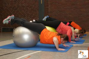 Frauen Machen Liegestütz mit den Füßen auf einem Gymnastikball