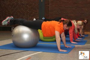 Frauen Machen Liegestütz mit den Füßen auf einem Gymnastikball