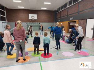 kinderturnen7 Eltern und Kinder stehen beim Turnen in der Sporthalle
