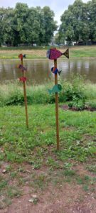Pfosten verziert mit Fischen am Fluss