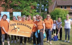 Mitglieder des TuS Eldagsen halten einen Banner mit dem Vereinslogo in die Kamera