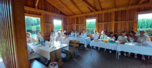 Viele Frauen sitzen beim Dinner in Weiß auf einer Bank mit gedecktem Tisch