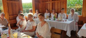 Viele Frauen sitzen beim Dinner in Weiß auf einer Bank mit gedecktem Tisch